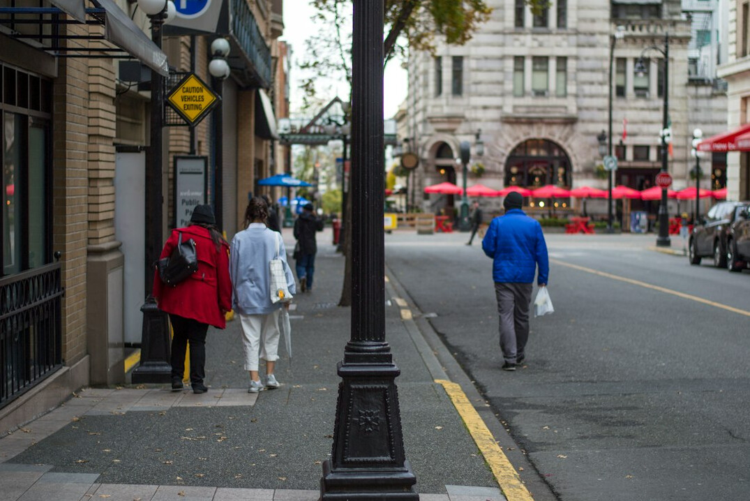 Diverse pedestrians crossing a busy downtown Canadian street in autumn light